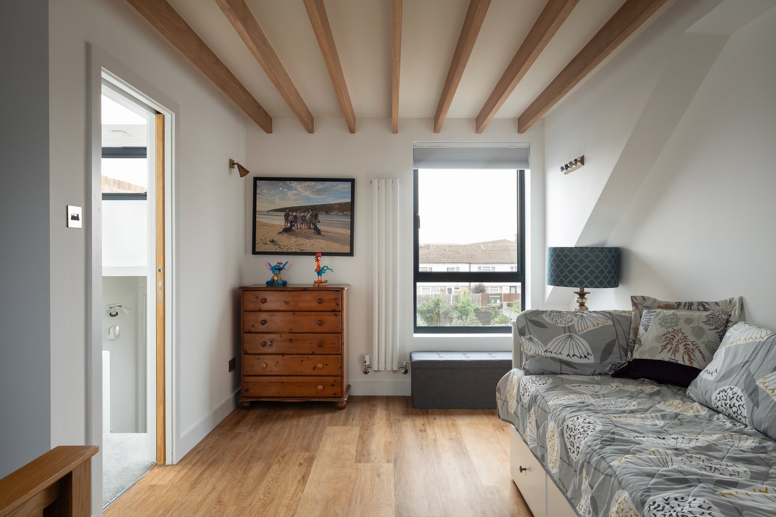 Loft living room with exposed timber beams and hardwood floor at Keogh Road