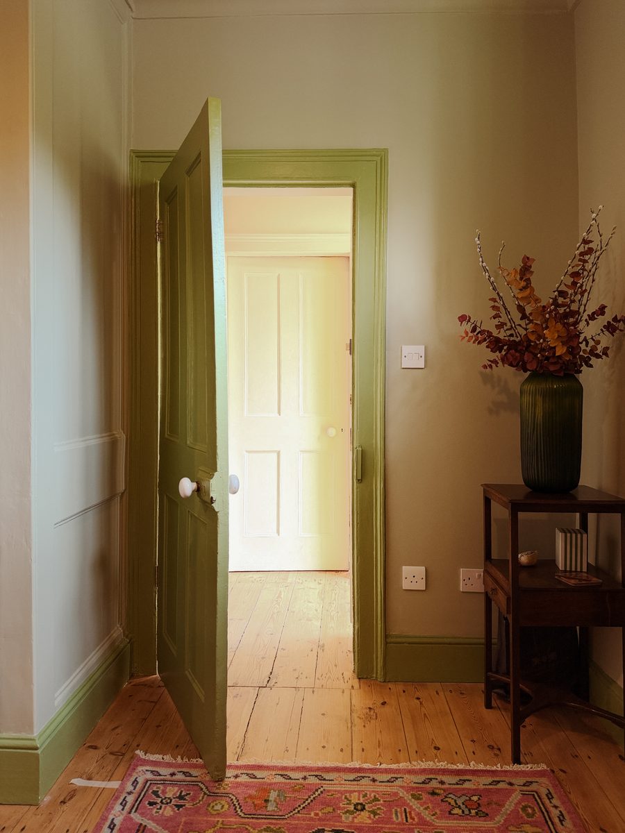 Limehouse Cottage: hallway with the green painted doors and the restored original floorboards