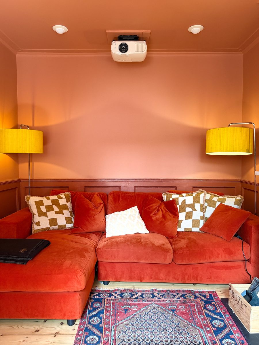 Limehouse Cottage: snug with a red corner sofa and panelled walls
